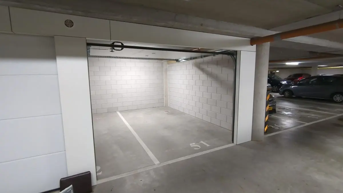 Open lock-up storage unit with a view of the parking garage beneath Haageinderhof